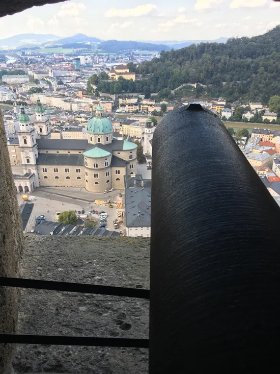 Historische Kanone mit Blick auf den Salzburger Dom und die Stadt aus einem Festungsfenster